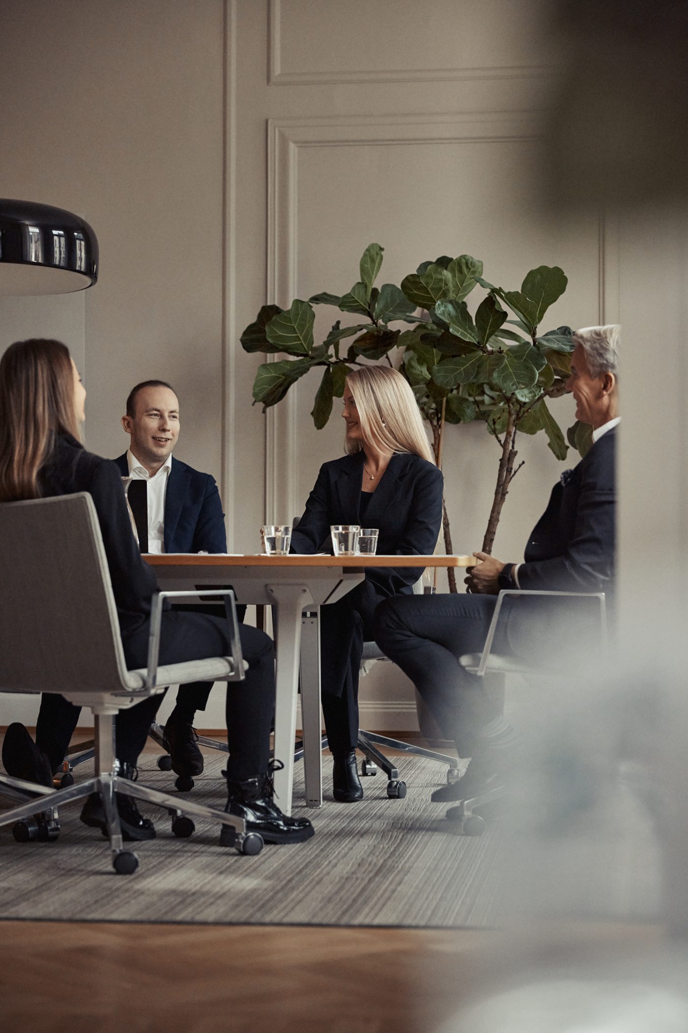Fyra kollegor i ett mötesrum på ett kontor